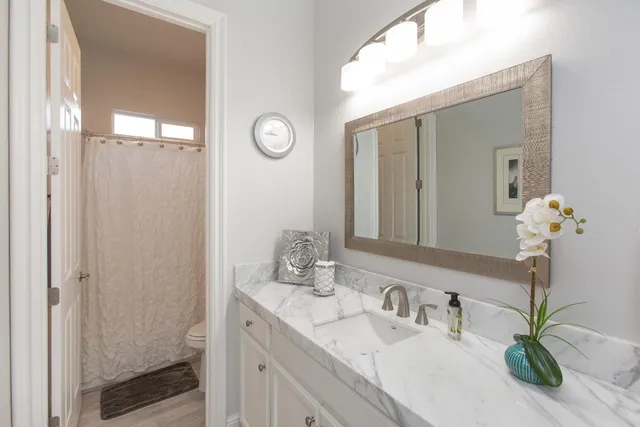 a bathroom with a granite countertop sink and a mirror
