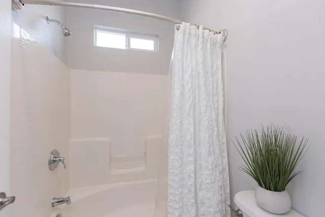 a bathroom with a shower curtain a mirror and a shower curtain