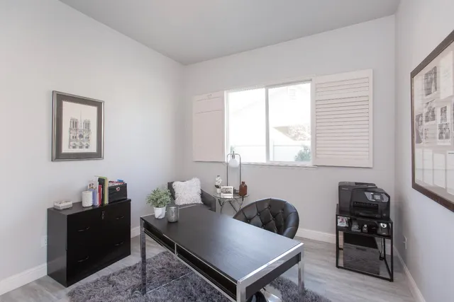 a view of a workspace with furniture and a window