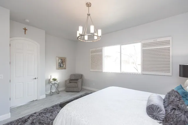 a bedroom with a bed and a chandelier