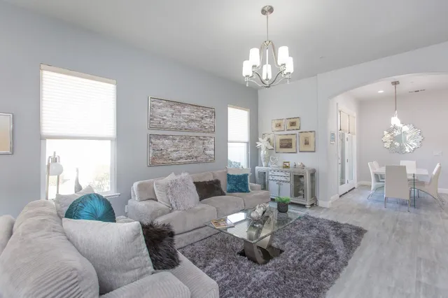 a living room with furniture chandelier and a large window