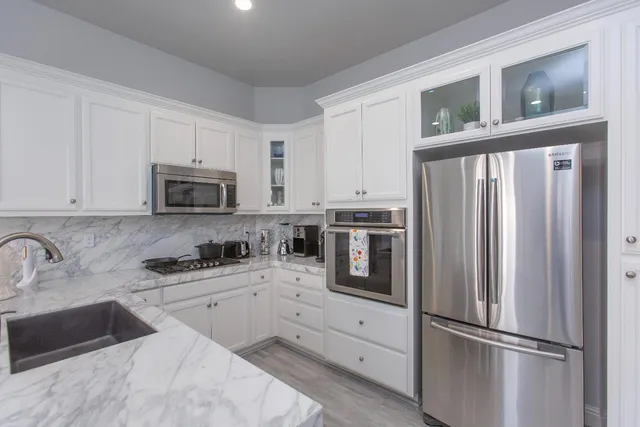a kitchen with white cabinets and stainless steel appliances