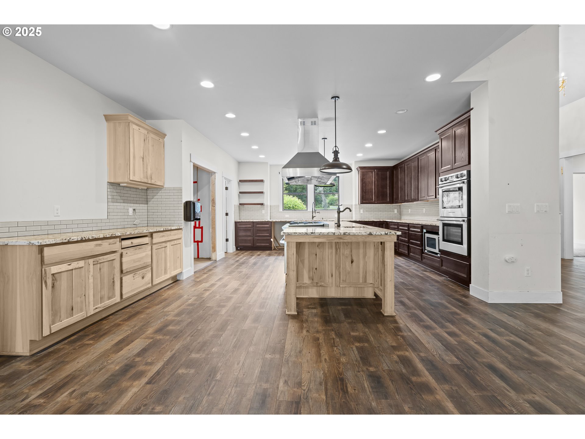 39665 Southeast Rude Road Sandy, OR 97055 - Photo 15 of 48 a kitchen with stainless steel appliances kitchen island wooden floors wooden cabinets and entryway
