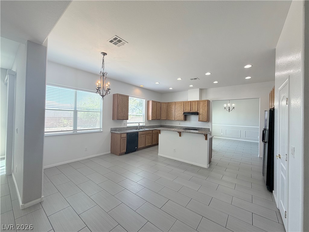 6116 Rabbit Track Street Las Vegas, NV 89130 - Photo 4 of 28 A well-lit kitchen with granite countertops and a spacious dining area awaits.