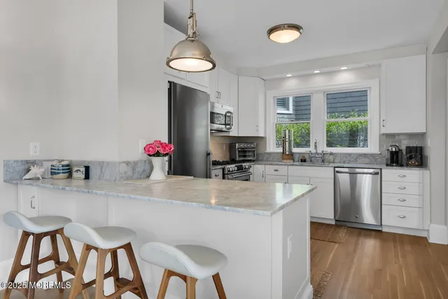 a kitchen with cabinets stainless steel appliances and a window