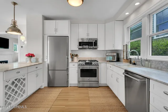 a kitchen with cabinets stainless steel appliances and a window