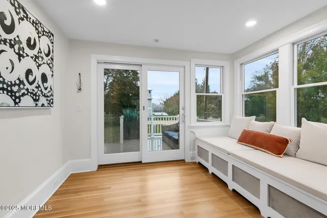 a living room with furniture a wooden floor and next to a window