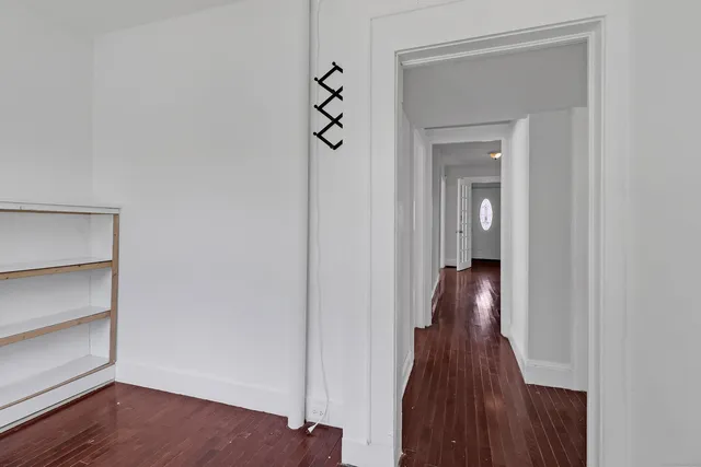 a view of a hallway with wooden floor and closet