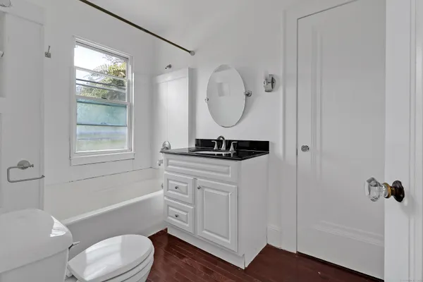 a bathroom with a toilet a sink and a mirror