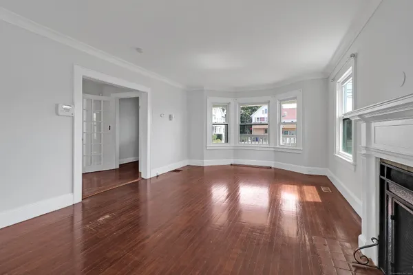 an empty room with wooden floor and fireplace