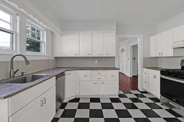 a kitchen with a sink a stove and cabinets