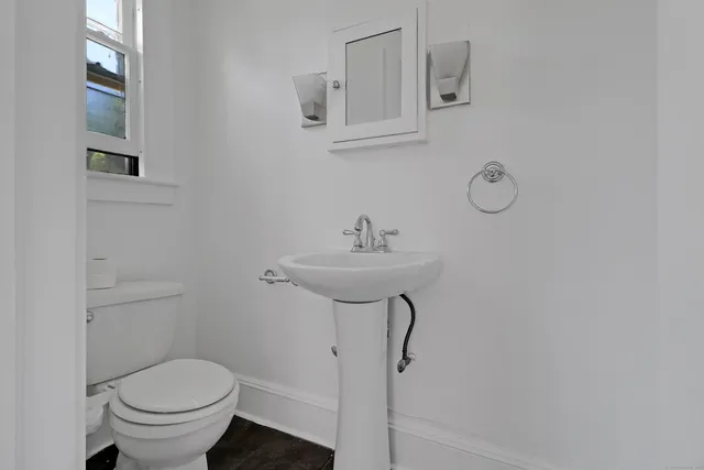 a bathroom with a sink toilet and a mirror