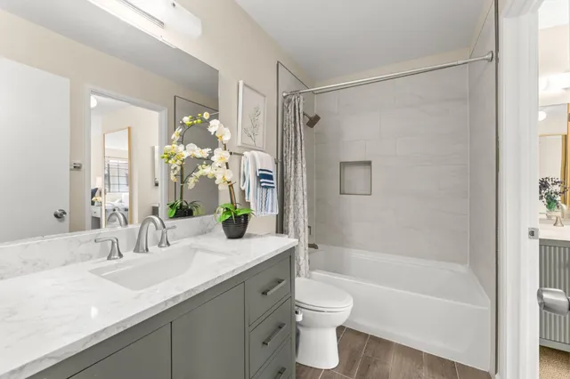 a bathroom with a granite countertop sink a toilet and shower