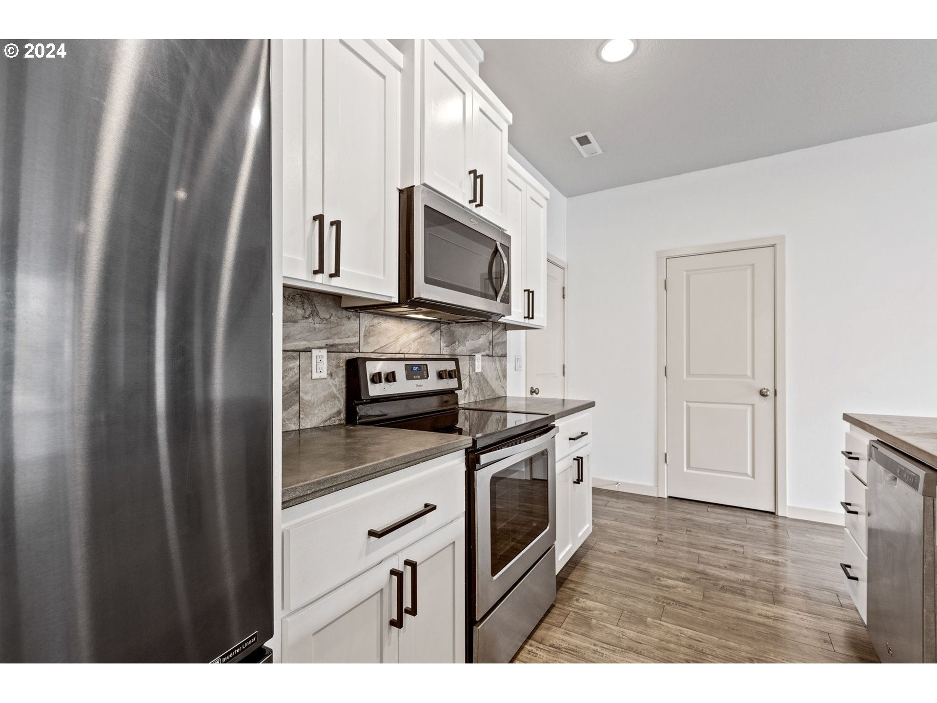 117 North 44th Place Ridgefield, WA 98642 - Photo 12 of 30 a kitchen with stainless steel appliances granite countertop a refrigerator a stove a sink and dishwasher with wooden floor