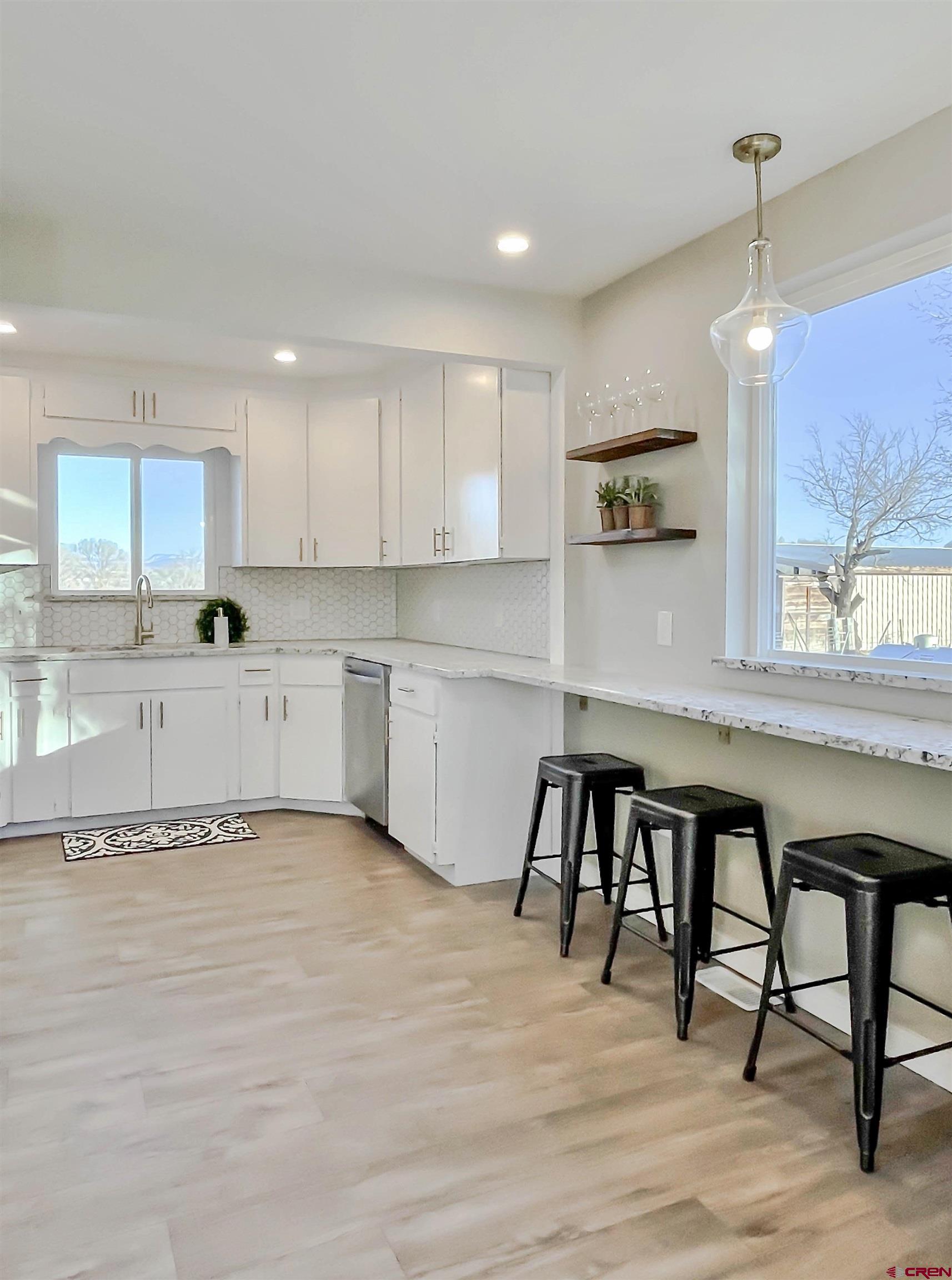 4956 1550 Road Delta, CO 81416 - Photo 14 of 35 a kitchen with granite countertop a table chairs sink and cabinets