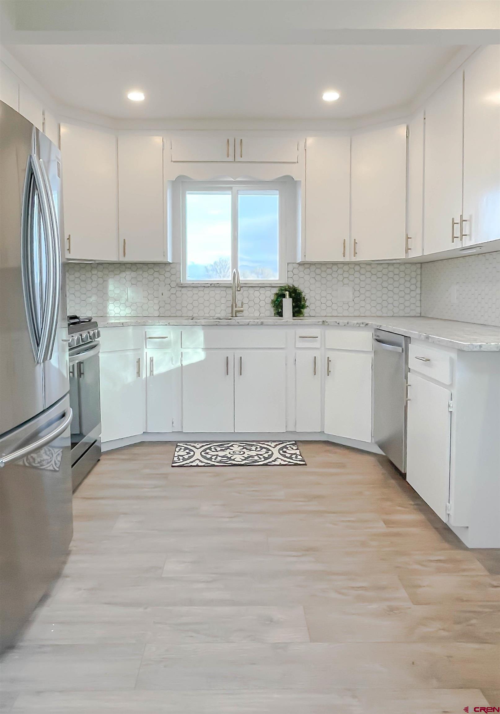 4956 1550 Road Delta, CO 81416 - Photo 15 of 35 a kitchen with stainless steel appliances granite countertop a refrigerator sink and cabinets