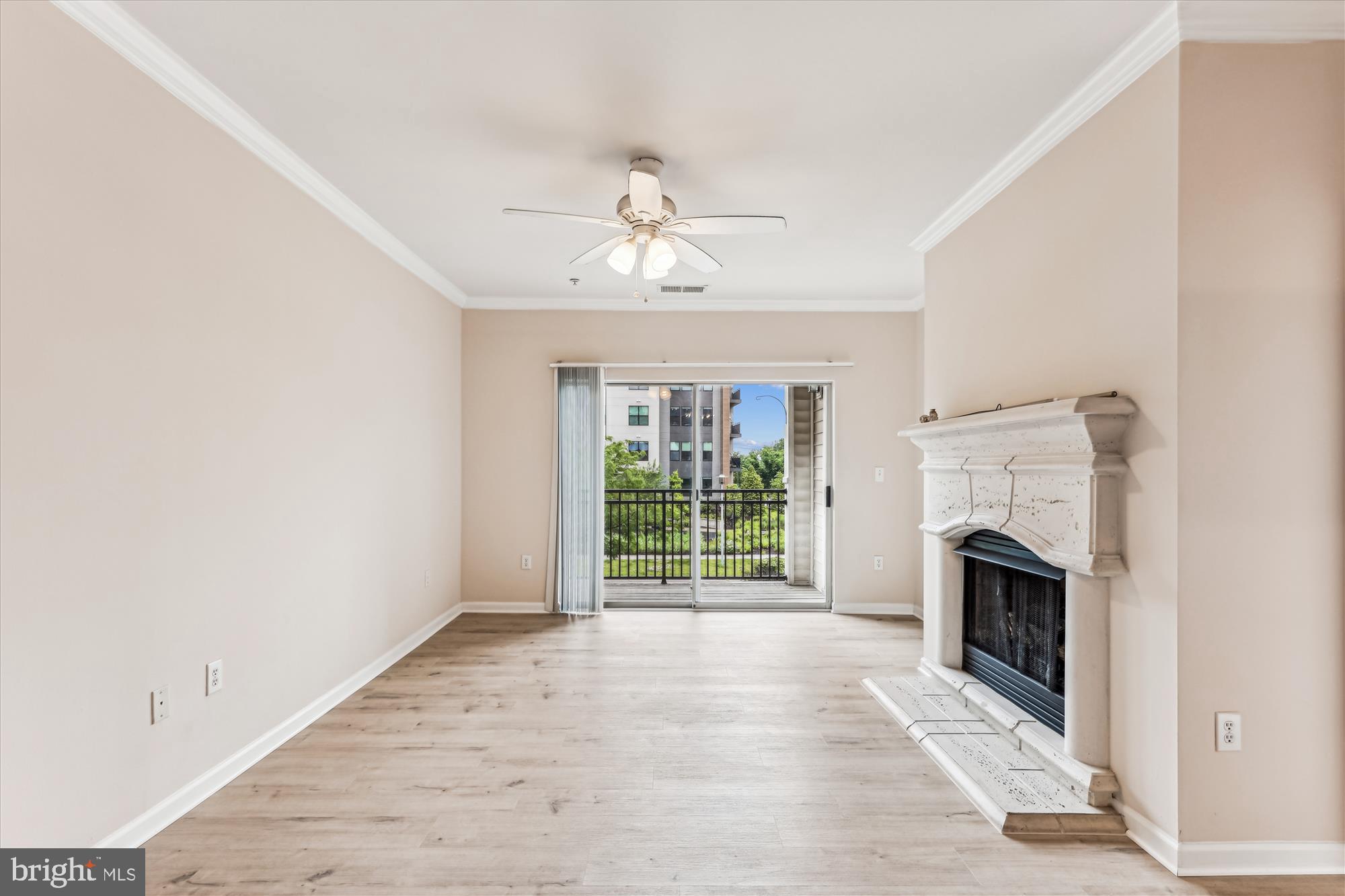 12941 Centre Park Circle, Unit 216 Herndon, VA 20171 - Photo 3 of 44 a view of an empty room with a fireplace and a window