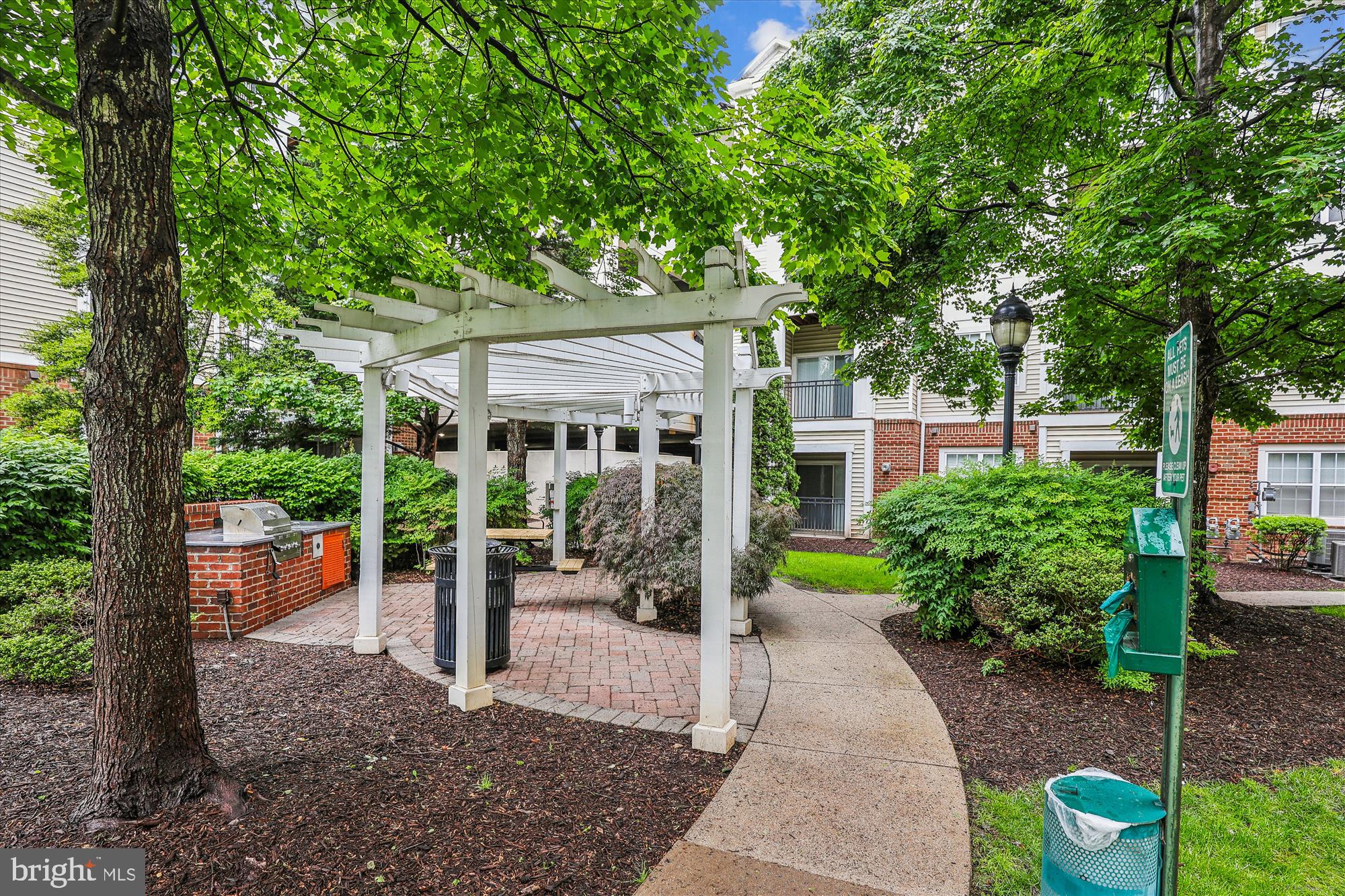 12941 Centre Park Circle, Unit 216 Herndon, VA 20171 - Photo 43 of 44 a view of a patio with table and chairs potted plants and large tree