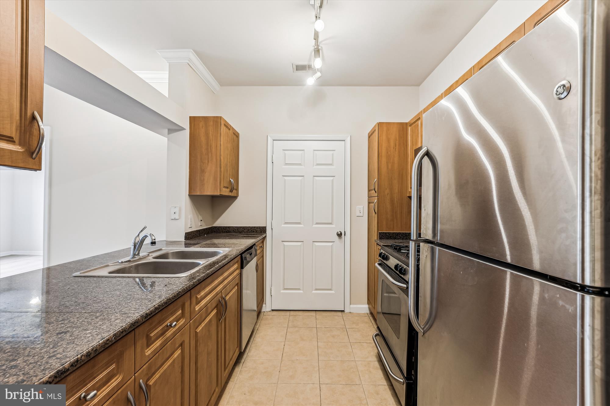 12941 Centre Park Circle, Unit 216 Herndon, VA 20171 - Photo 5 of 44 a kitchen with stainless steel appliances granite countertop a refrigerator and a sink