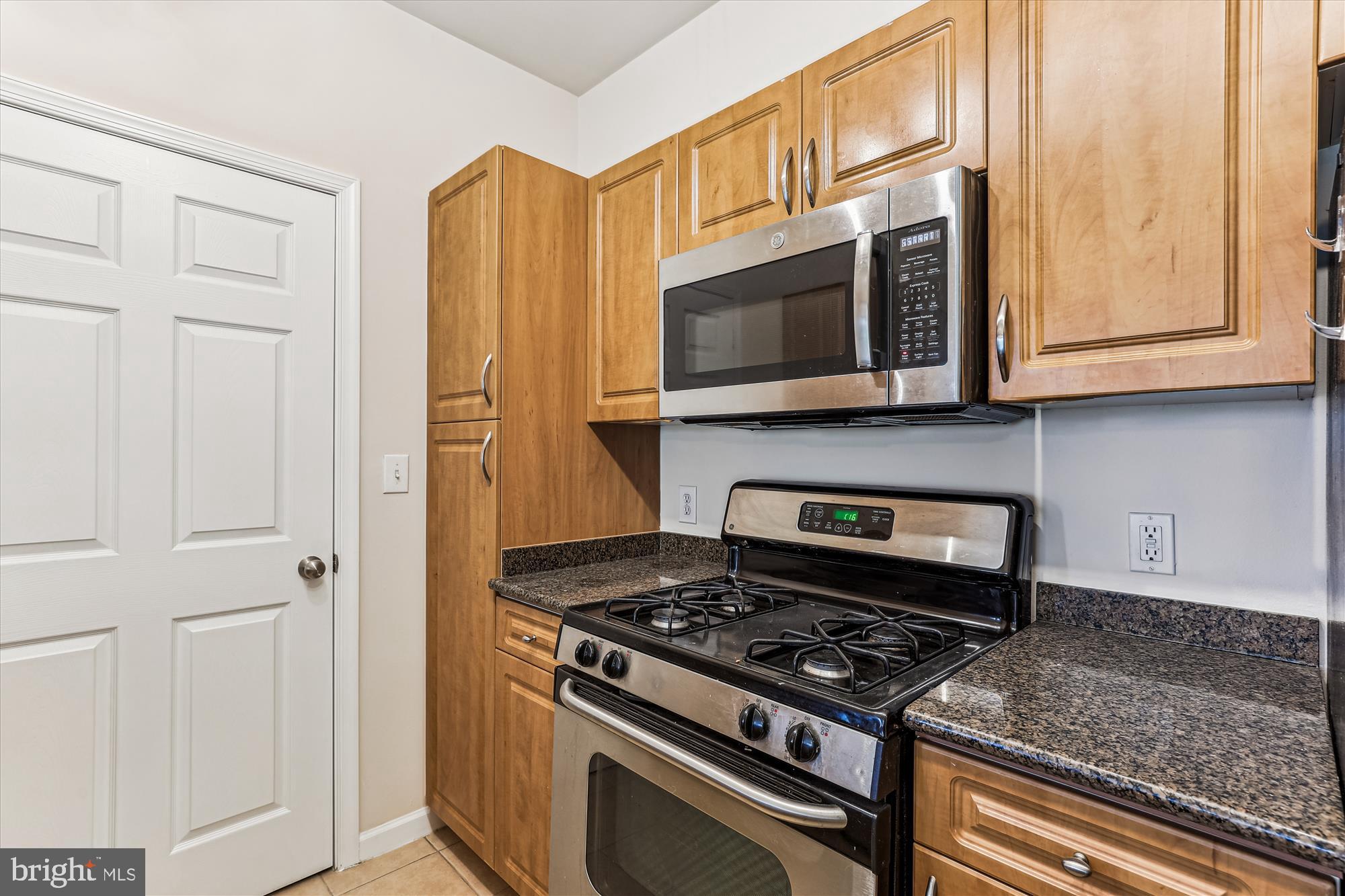 12941 Centre Park Circle, Unit 216 Herndon, VA 20171 - Photo 6 of 44 a kitchen with stainless steel appliances granite countertop a stove and a microwave