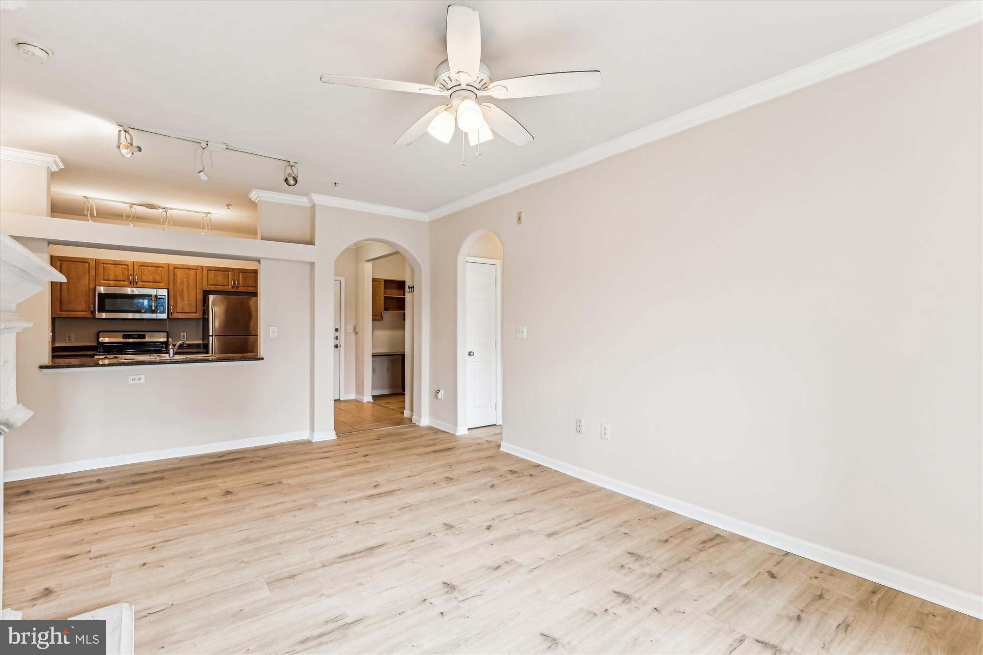 12941 Centre Park Circle, Unit 216 Herndon, VA 20171 - Photo 8 of 44 an empty room with fan and way to kitchen