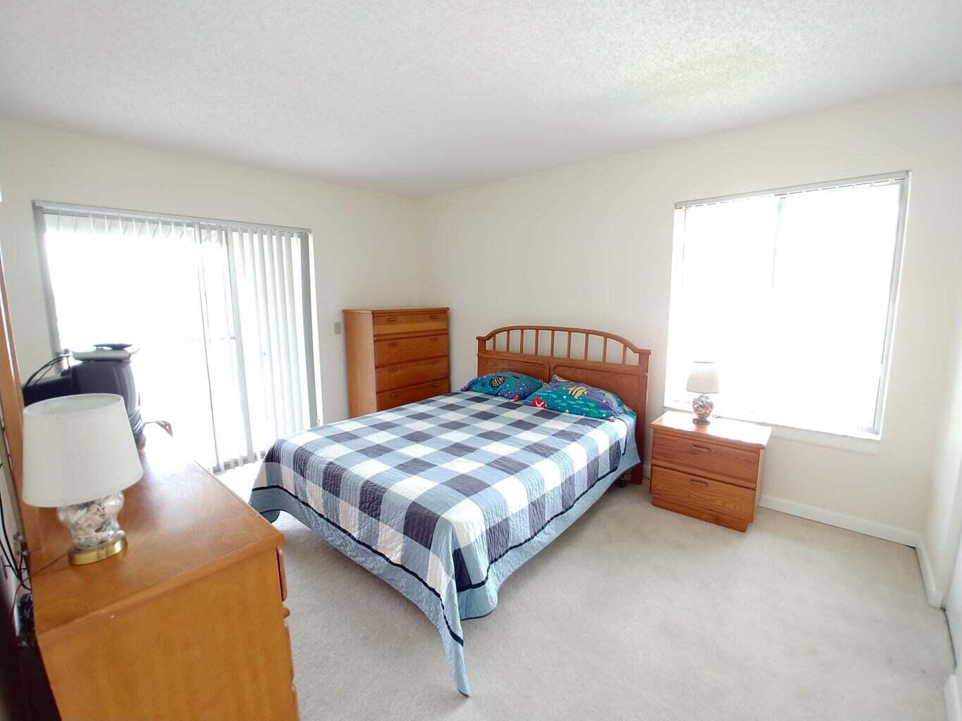 6258 Chasewood Drive, Unit E Jupiter, FL 33458 - Photo 11 of 15 a bedroom with bed and window