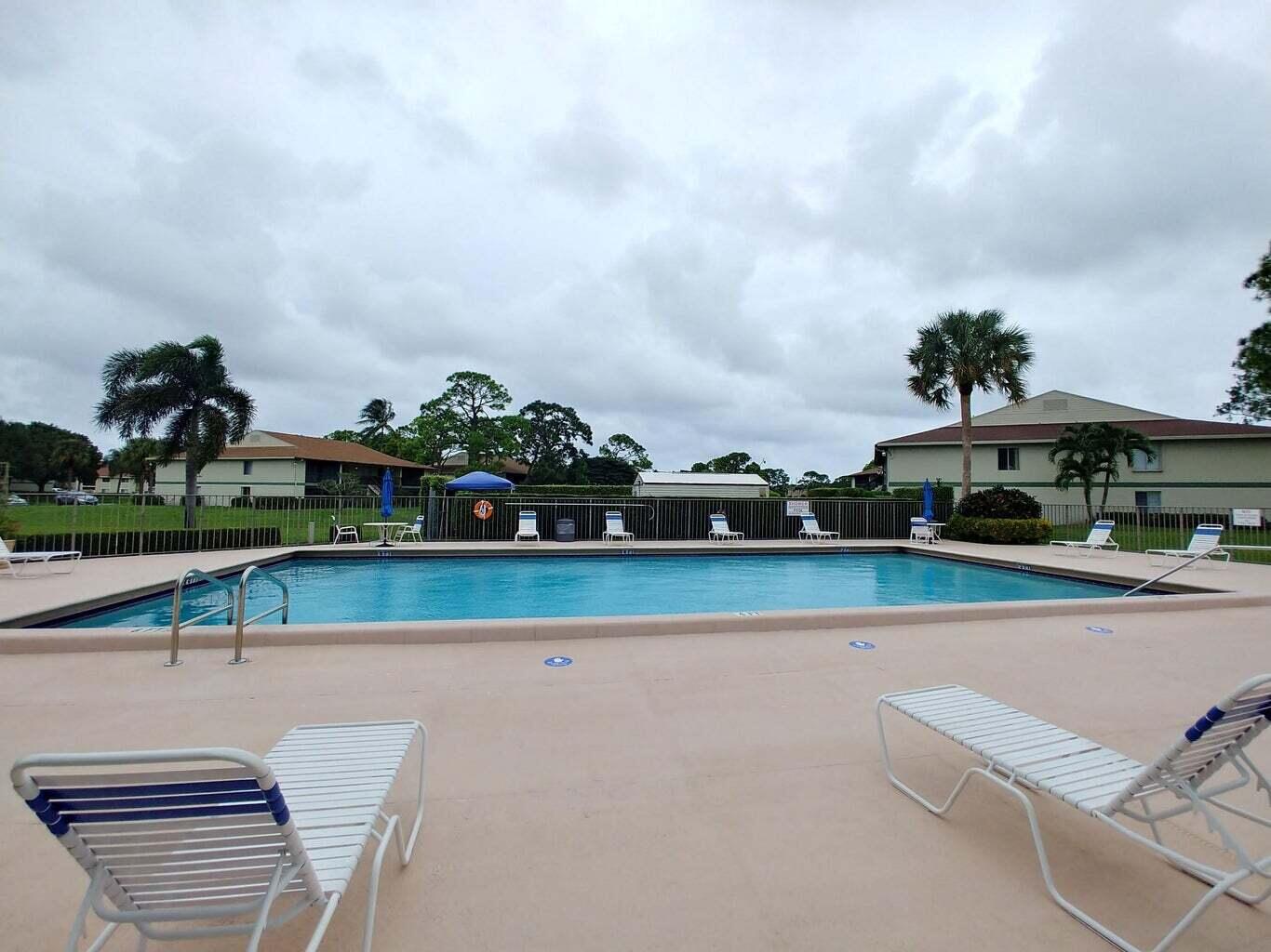 6258 Chasewood Drive, Unit E Jupiter, FL 33458 - Photo 2 of 15 a view of a swimming pool with outdoor seating