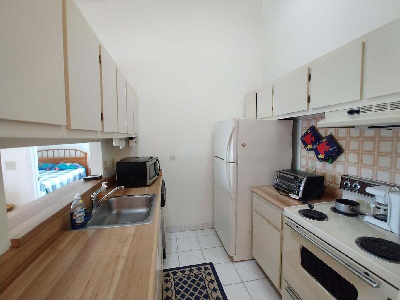 6258 Chasewood Drive, Unit E Jupiter, FL 33458 - Photo 7 of 15 a kitchen with stainless steel appliances a sink a stove a refrigerator and cabinets