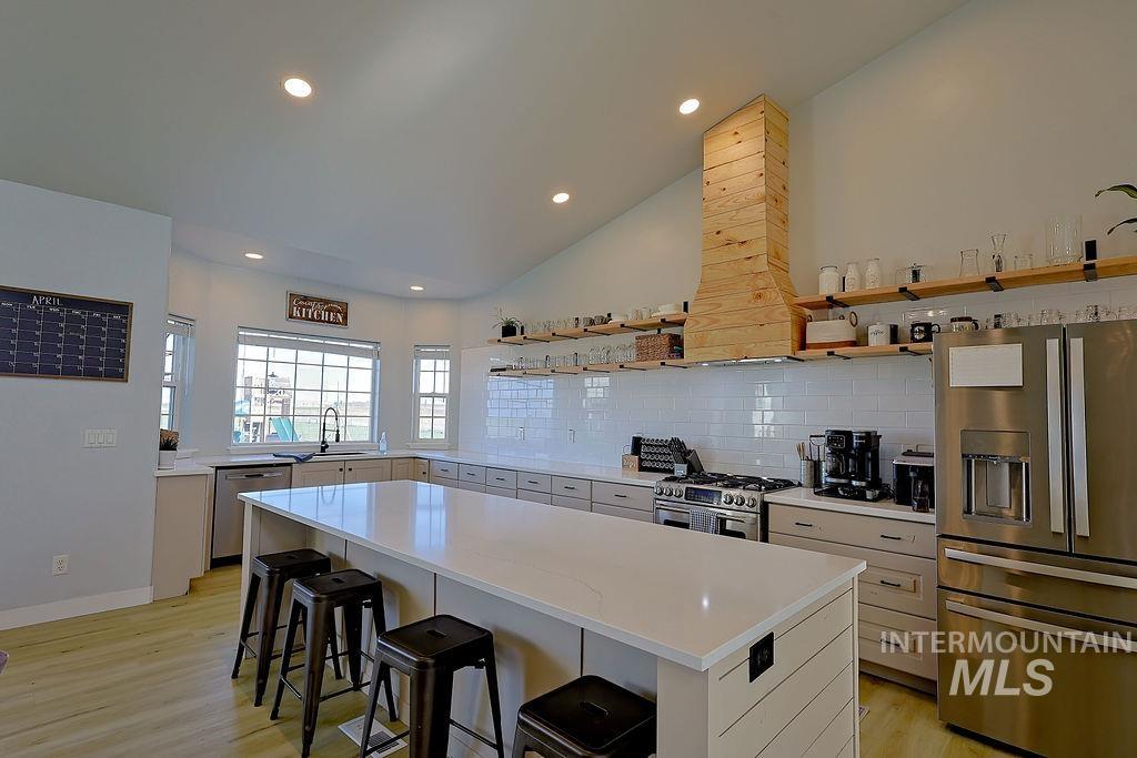 24 Harris Circle Shoshone, ID 83352 - Photo 12 of 39 Kitchen with stainless steel appliances, a kitchen bar, light wood-style floors, open shelves, and a kitchen island