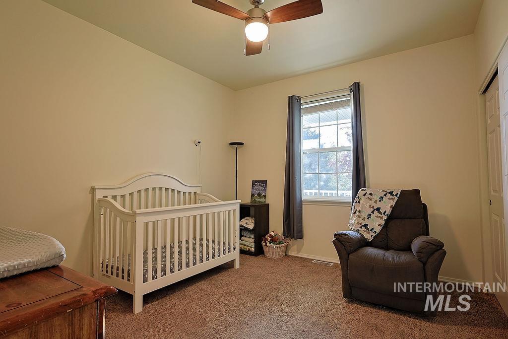 24 Harris Circle Shoshone, ID 83352 - Photo 20 of 39 Carpeted bedroom featuring a crib and ceiling fan