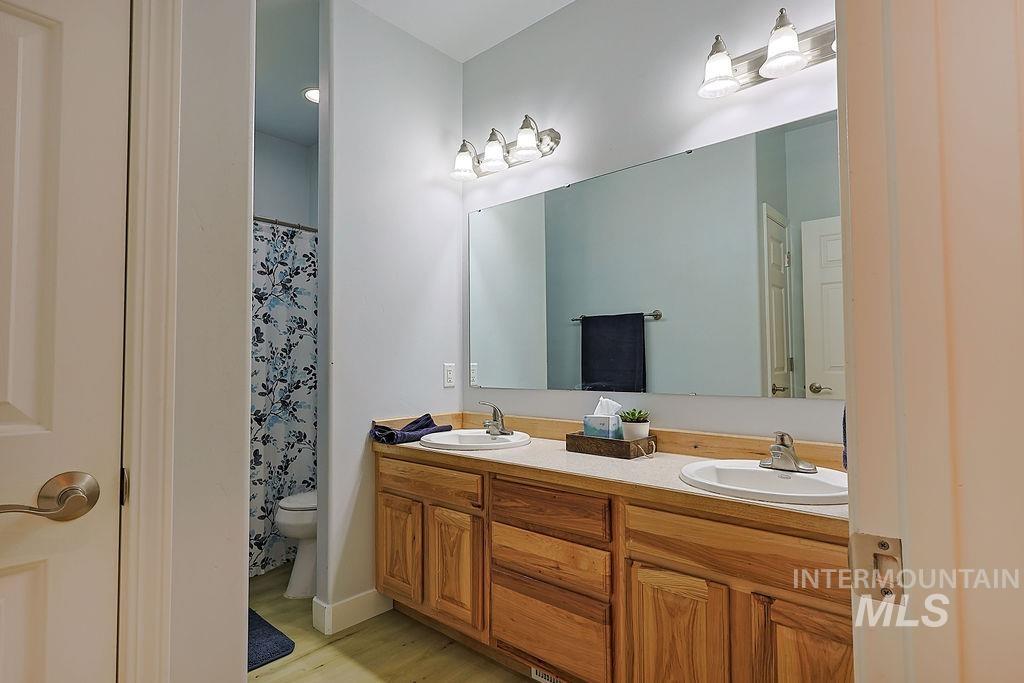24 Harris Circle Shoshone, ID 83352 - Photo 21 of 39 Bathroom featuring double vanity, a shower with shower curtain, and light wood-style flooring