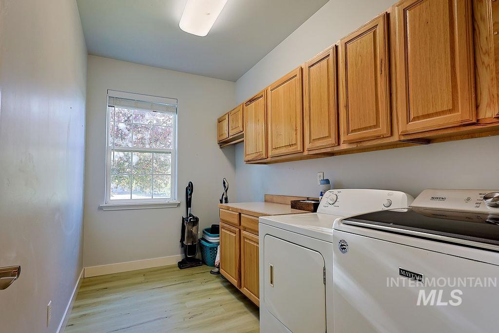 24 Harris Circle Shoshone, ID 83352 - Photo 27 of 39 Laundry area with light wood-style floors, cabinet space, and washer and dryer