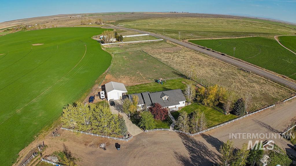 24 Harris Circle Shoshone, ID 83352 - Photo 35 of 39 Expansive property featuring a white residence with a dormer, an adjacent metal outbuilding, a paved driveway, and mature landscaping