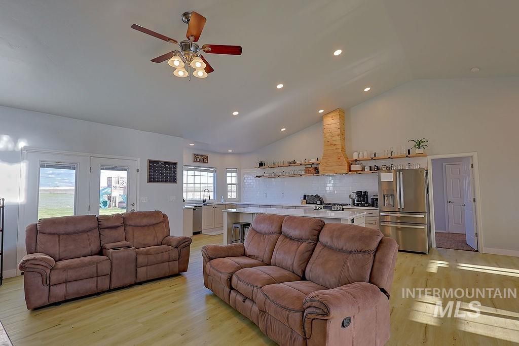 24 Harris Circle Shoshone, ID 83352 - Photo 6 of 39 Living room with vaulted ceiling, light wood-style flooring, ceiling fan, and recessed lighting