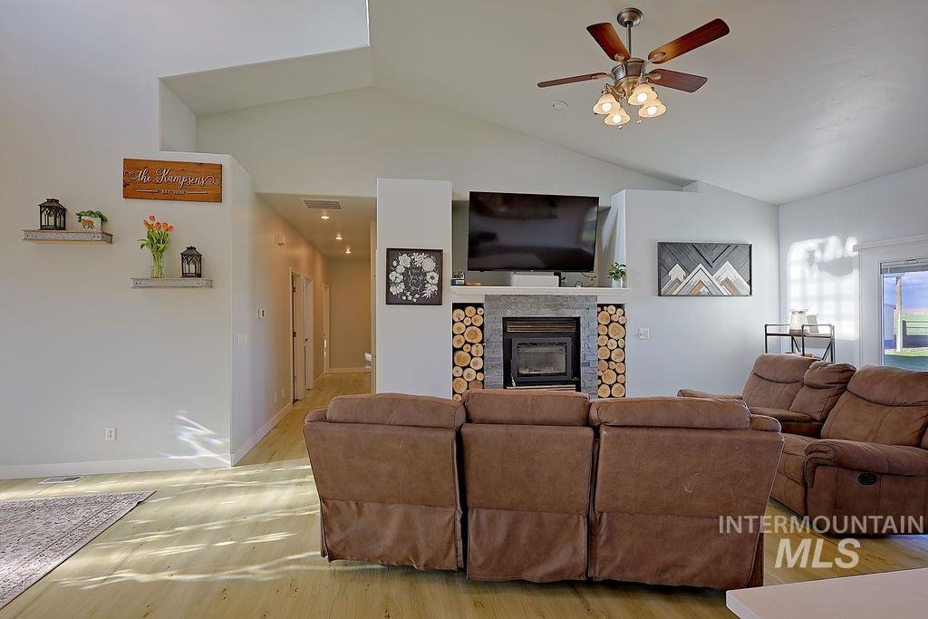 24 Harris Circle Shoshone, ID 83352 - Photo 8 of 39 Living area with a ceiling fan, light wood-type flooring, lofted ceiling, and a fireplace