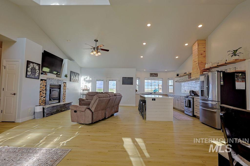 24 Harris Circle Shoshone, ID 83352 - Photo 9 of 39 Living room with vaulted ceiling, light wood-style floors, recessed lighting, a fireplace, and ceiling fan
