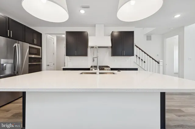 a kitchen with stainless steel appliances a refrigerator and microwave