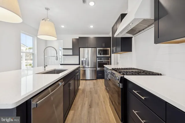 a large kitchen with stainless steel appliances granite countertop a sink and a stove