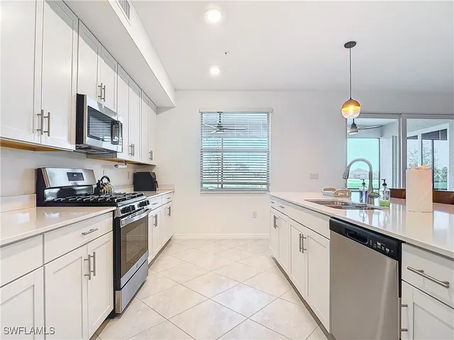 a kitchen with granite countertop a sink a stove and cabinets