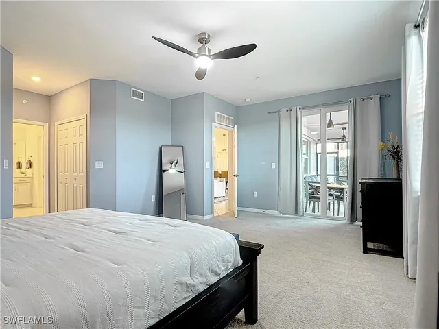 a spacious bedroom with a large bed and a chandelier