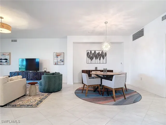 a living room with furniture a chandelier and a flat screen tv