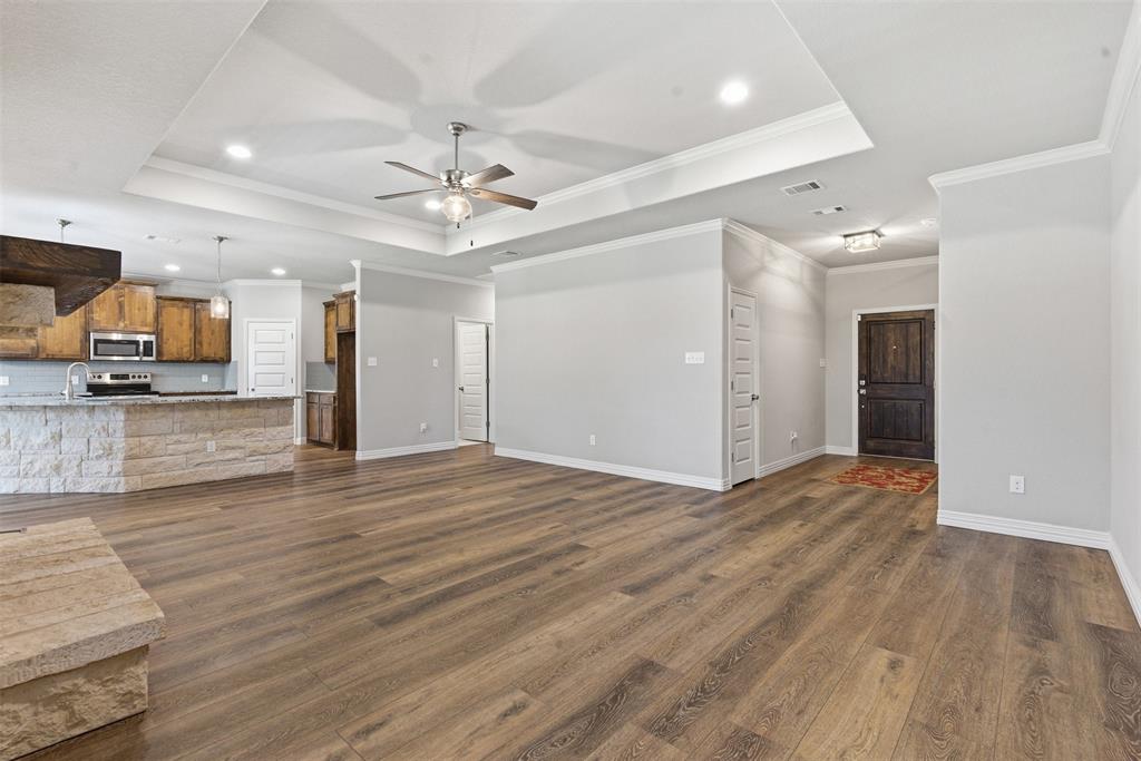 906 Chestnut Grove Drive Cleburne, TX 76033 - Photo 12 of 29 a view of a kitchen with wooden floor and a ceiling fan