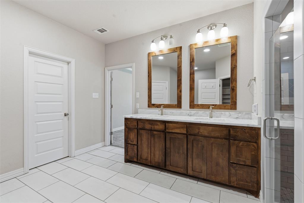 906 Chestnut Grove Drive Cleburne, TX 76033 - Photo 17 of 29 a spacious bathroom with a granite countertop sink and a mirror