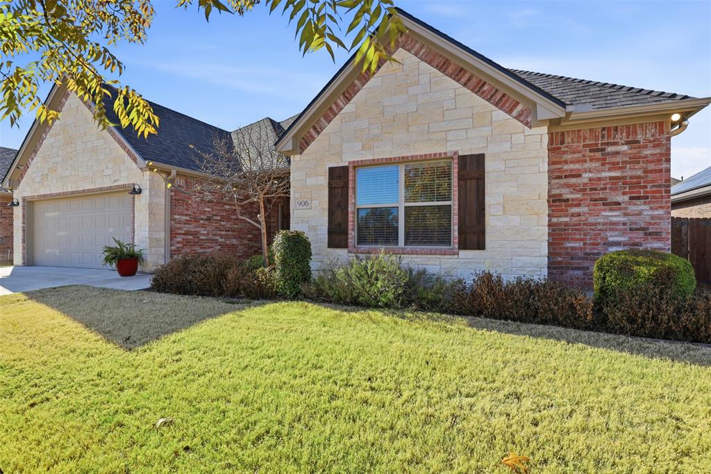 906 Chestnut Grove Drive Cleburne, TX 76033 - Photo 2 of 29 a view of a brick house with plants and large tree