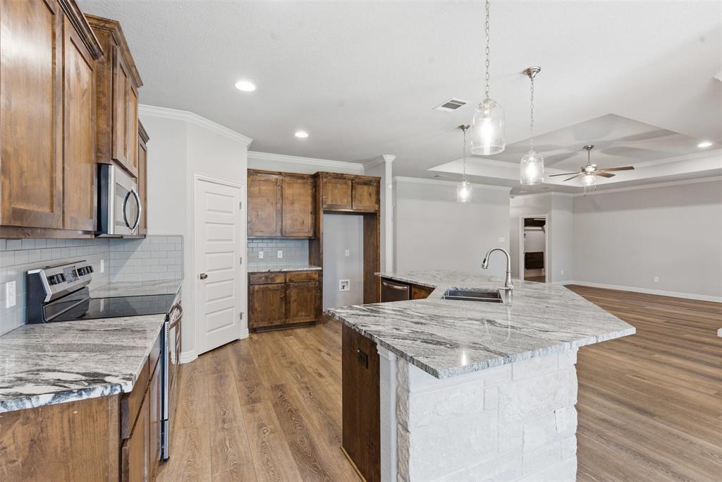906 Chestnut Grove Drive Cleburne, TX 76033 - Photo 6 of 29 a kitchen with stainless steel appliances granite countertop a kitchen island a stove and a sink