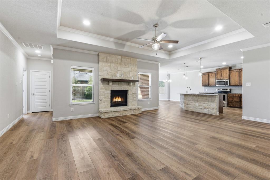 906 Chestnut Grove Drive Cleburne, TX 76033 - Photo 9 of 29 an empty room with wooden floor fireplace cabinet and windows