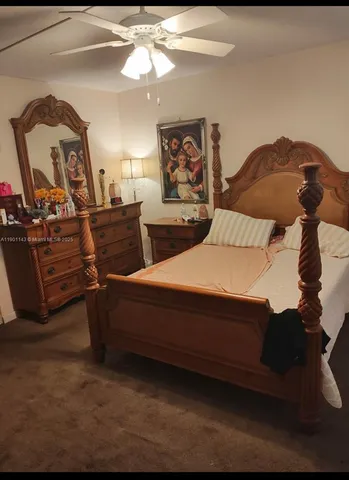 a bedroom with a bed lamps and a large mirror