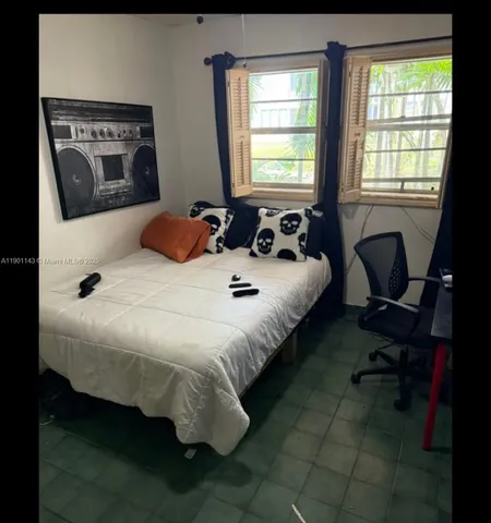 a bed sitting in a bedroom next to a window