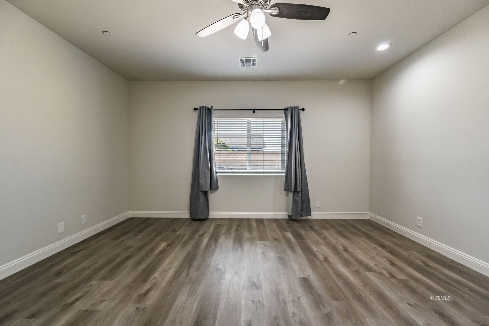 1031 West Church Avenue Ridgecrest, CA 93555 - Photo 25 of 49 a view of an empty room with a window and wooden floor