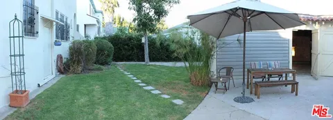 a view of backyard with seating space and trees